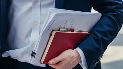 homme marchant dans la rue avec des notes sous le bras