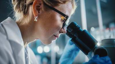 Female scientist looking through a microscope