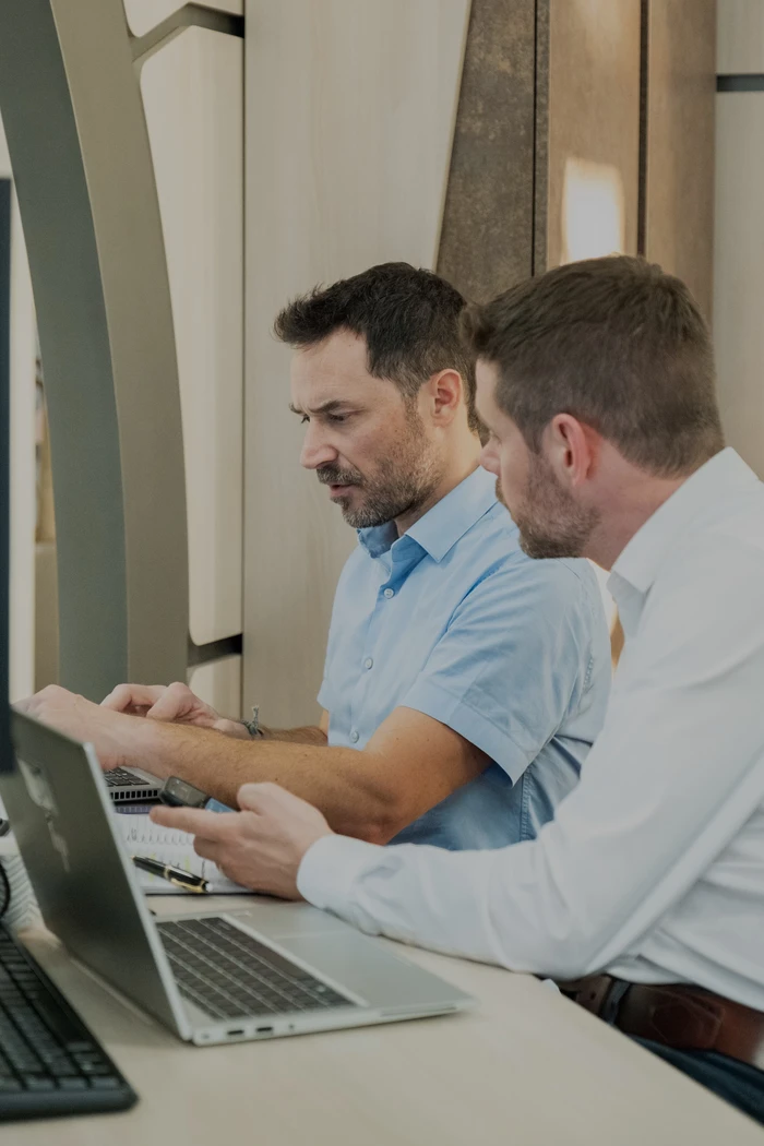 Deux hommes qui travaillent devant un ordinateur