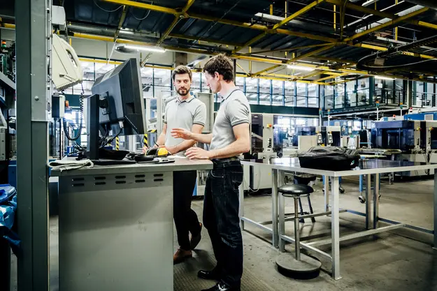 Engineers reviewing systems at an industrial workstation, illustrating asset inventory in ICS environments