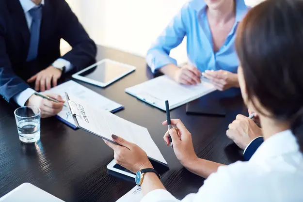 Business professionals reviewing a contract document during a meeting