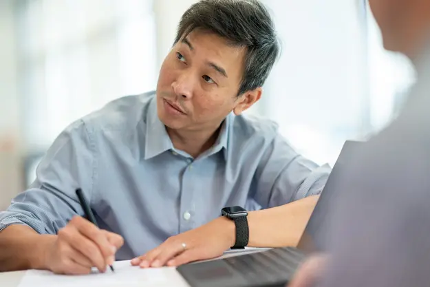 Team member taking notes in a meeting