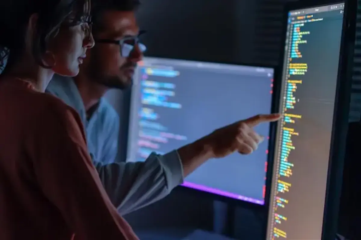 Deux agents de cybersécurité devant un écran de monitoring