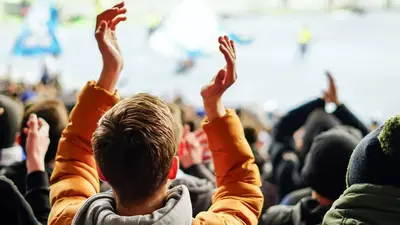 Event goer, hands above his head clapping  
