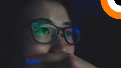Une analyste regarde des données sur un écran d'ordinateur. 