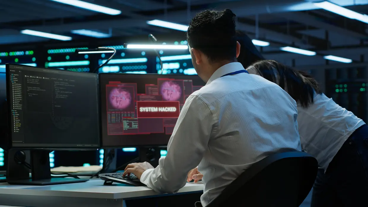 Cybersicherheitsanalysten in einem Security Operations Center, die auf mehreren Bildschirmen auf kritische Malware-Warnmeldungen reagieren und Bedrohungen in Echtzeit untersuchen