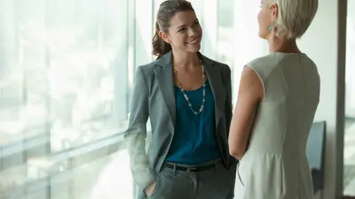 Two colleagues having a conversation near a window