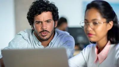 Two team members looking at a laptop screen