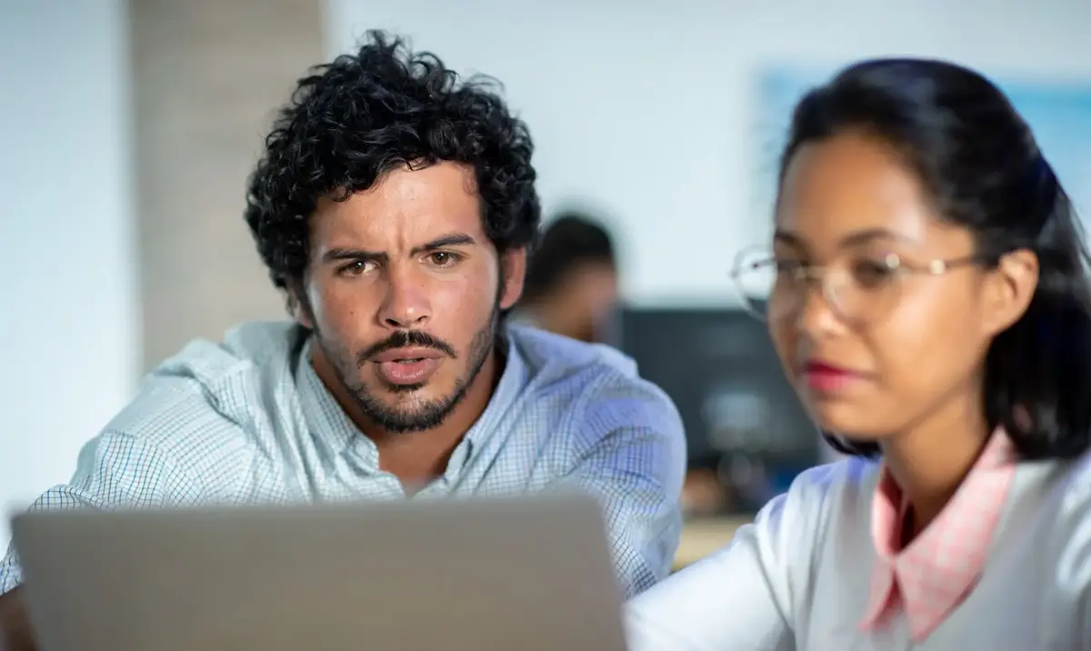 Two team members looking at a laptop screen