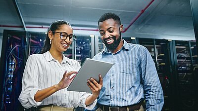 Un homme et une femme qui regardent une tablette dans un centre de donnée
