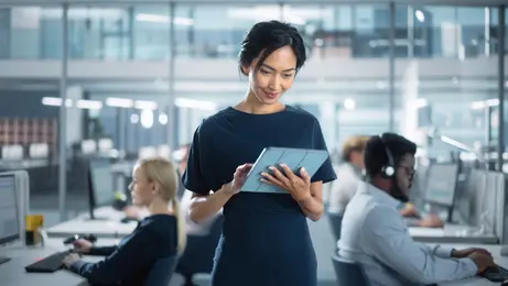 Femme debout utilisant une tablette tactile