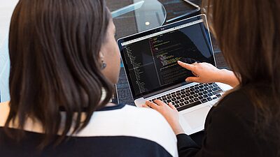 Deux femmes regardent un écran d'ordinateur 