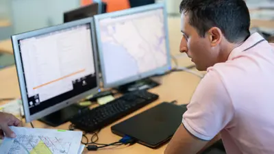 un homme devant 2 écrans d'ordinateur