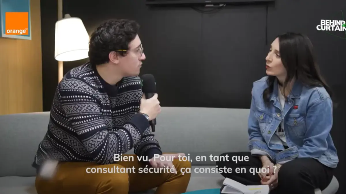 Un homme avec un micro et une femme discutant sur un canapé