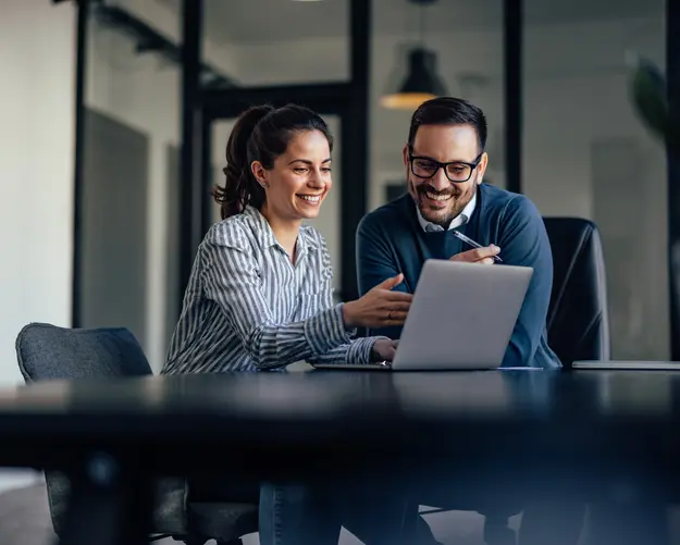 Business professionals collaborating on a laptop, illustrating a trusted cyber resilience partnership