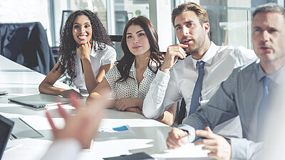 Two women and two men as a presenter in a meeting