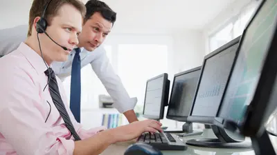 Deux hommes dont un opérateur regardent un écran de surveillance