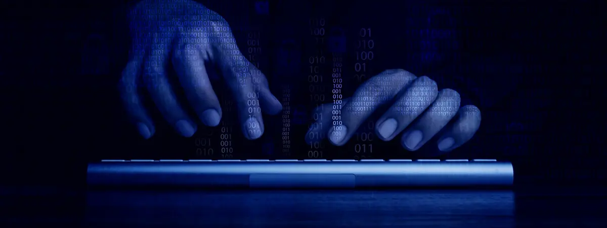Close-up of a hooded figure in a dark environment, surrounded by digital code and cybersecurity interface elements