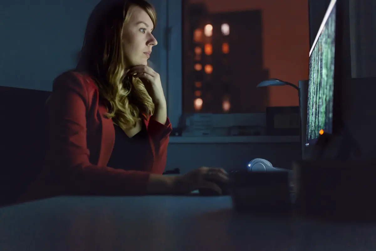 photo woman in front of a computer in the dark
