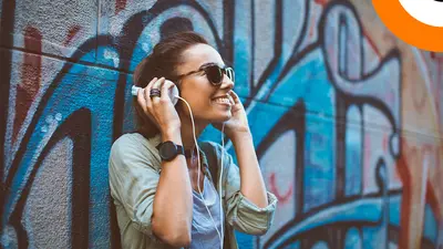 Les liens entre musique électronique, rap, hip hop et cybersécurité. Une jeune femme écoutant de la musique en souriant, à l'aide d'un casque stéréo.