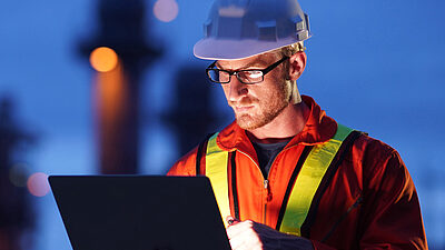 Worker interacting with a digital interface under blue lighting