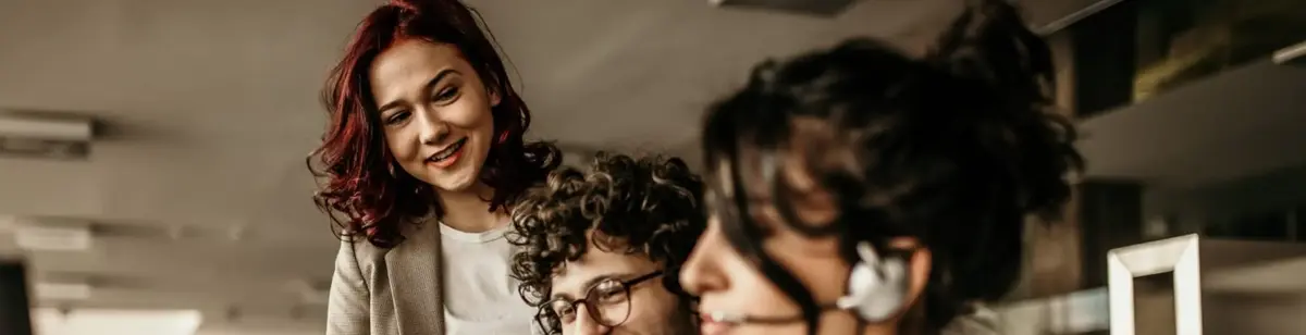 Une femme debout, regardant un homme et une femme assis