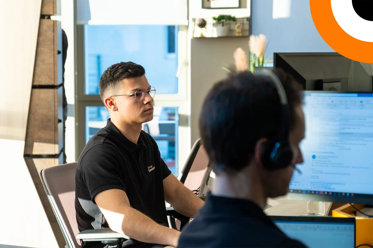Deux experts en cybersécurité travaillent côte à côté devant leurs ordinateurs. 