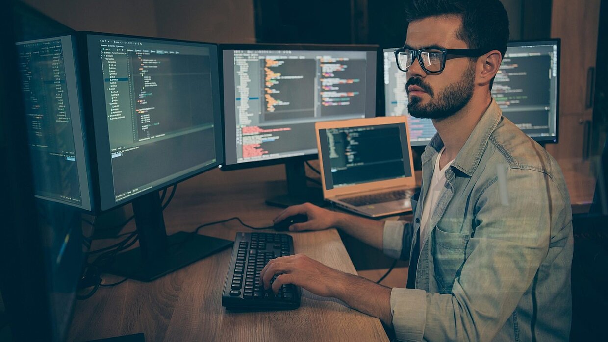 Analyst looking at information on several screens