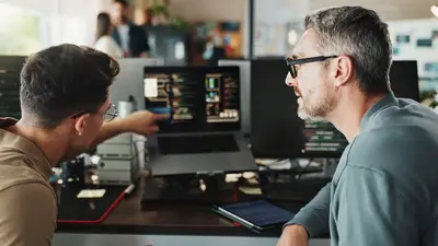 Zwei Männer am Computerbildschirm im Büro testen eine Softwarelösung