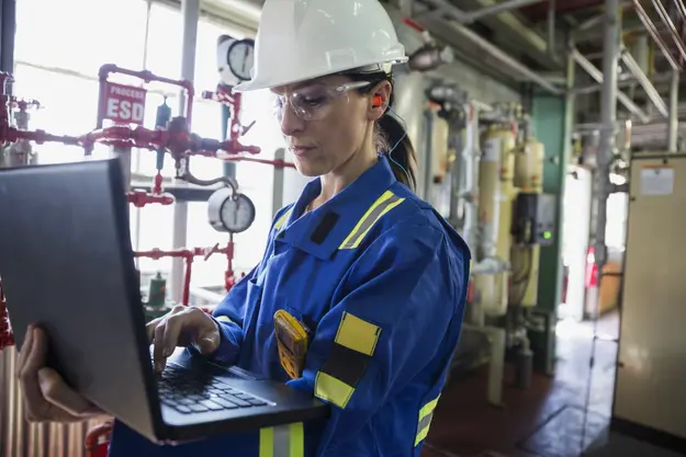 Woman in workwear using a screen in a technical room