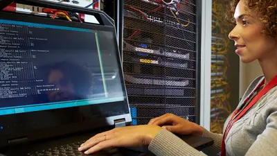 Femme dans une infrastructure de data center regarde des données