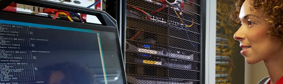 Femme dans une infrastructure de data center regarde des données
