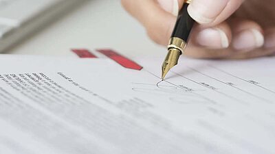 Une femme signe un document contractuel