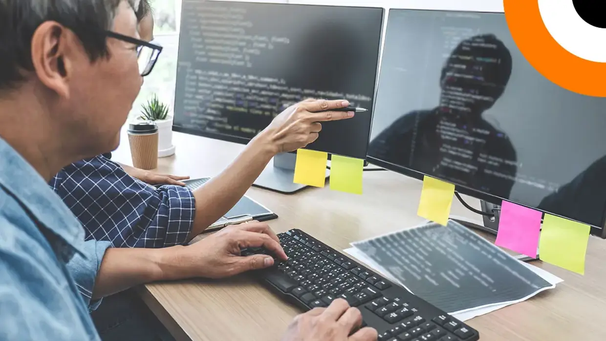 Deux experts en cybersécurité analysent des données sur un ordinateur. 