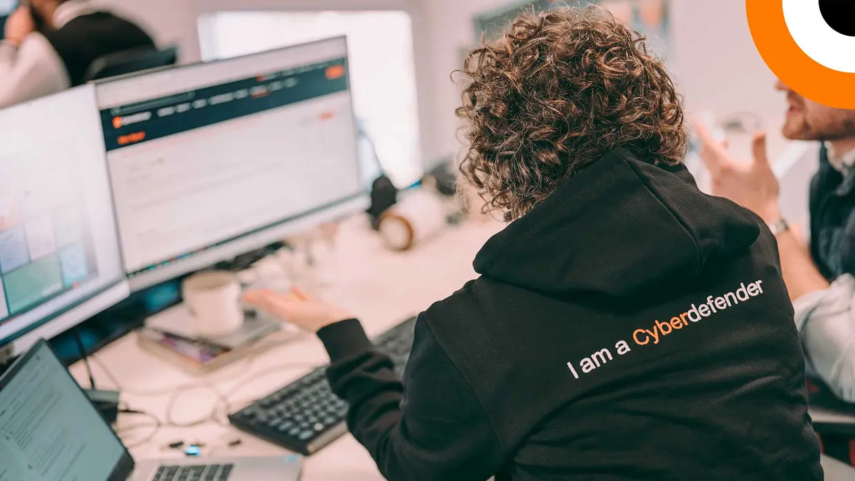 An Orange Cyberdefense employee working at a computer workstation.