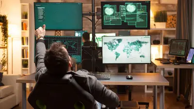 Going well - security professional looking at multiple screens with world data on them