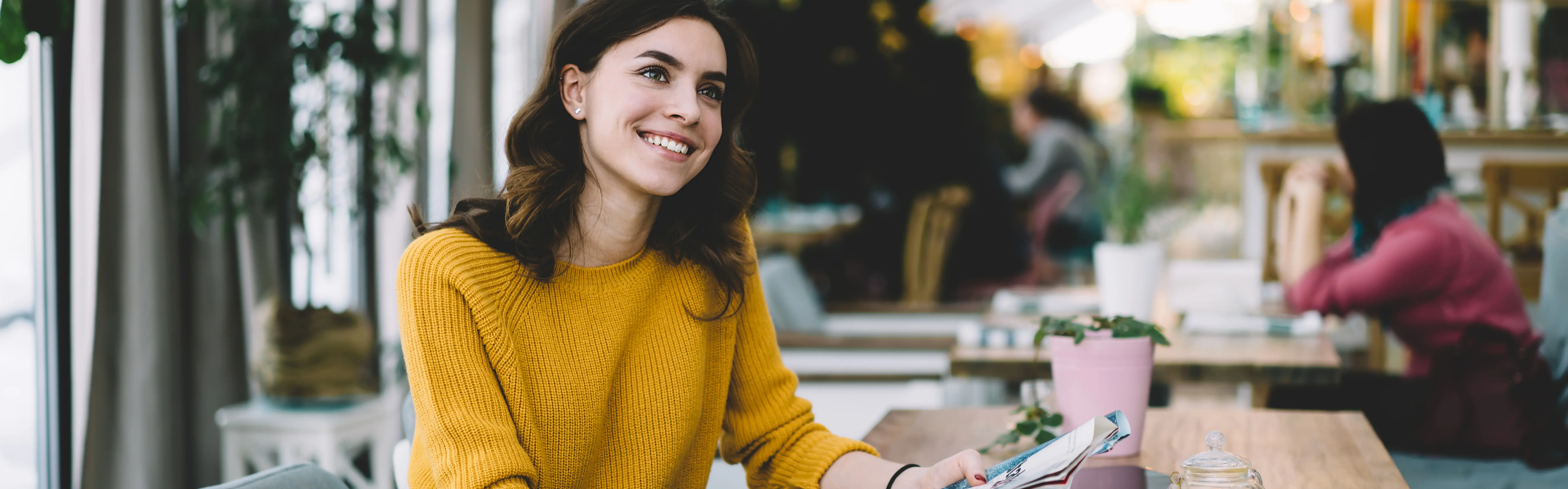 Afbeelding vrouw leest in cafe en kijkt naar rechts