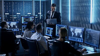 Plusieurs personnes travaillent ensemble dans une salle de serveurs informatiques. 