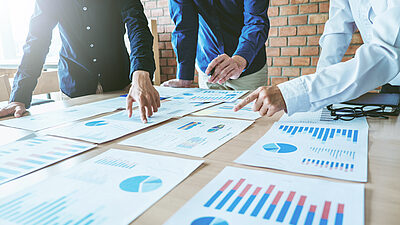 Team looking at a table of printed data charts