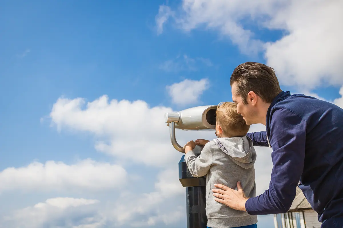 man and child watching clouds