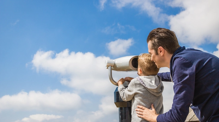 man and child watching clouds