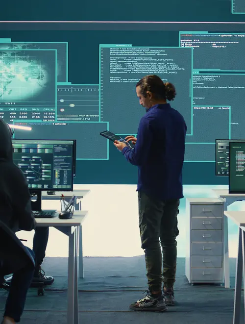 Team in front of computers with IT data projected on the walls