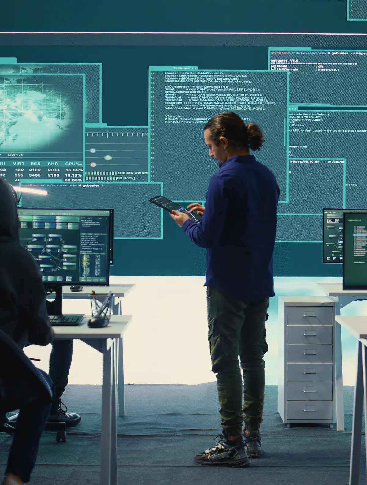 Team in front of computers with IT data projected on the walls