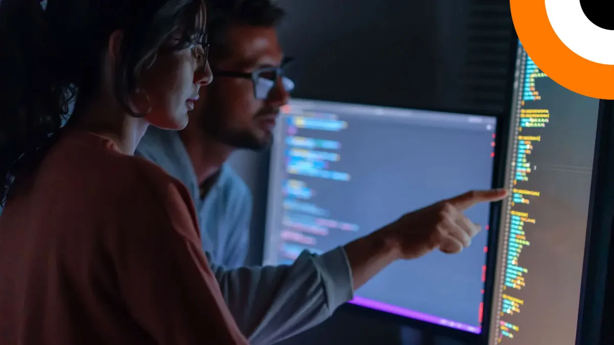 Un expert en cybersécurité pointe du doigt un écran disposé en mode horizontal. 