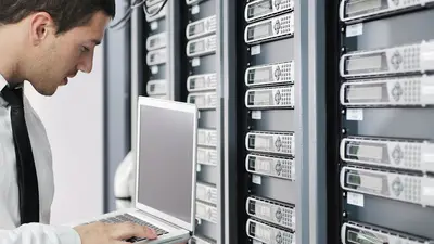 Un homme configure des disques durs dans un datacenter