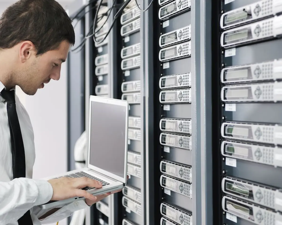 Un homme configure des disques durs dans un datacenter