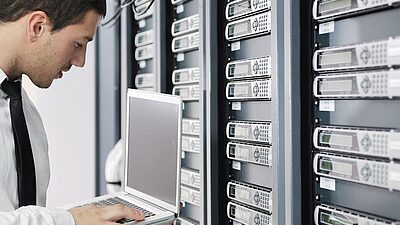 Un homme configure des disques durs dans un datacenter