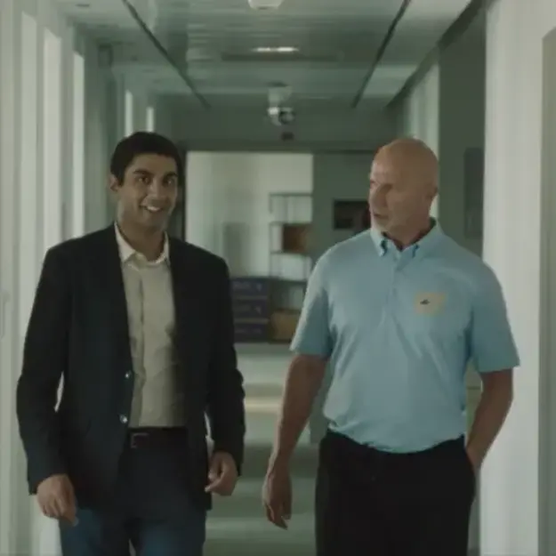 Two men walking through an office hallway