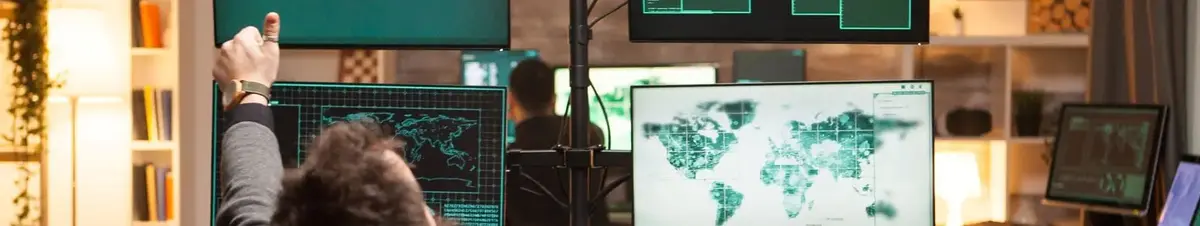 A person working in a high-tech control room or cybersecurity operations center, surrounded by multiple monitors displaying global maps, data, and security information.