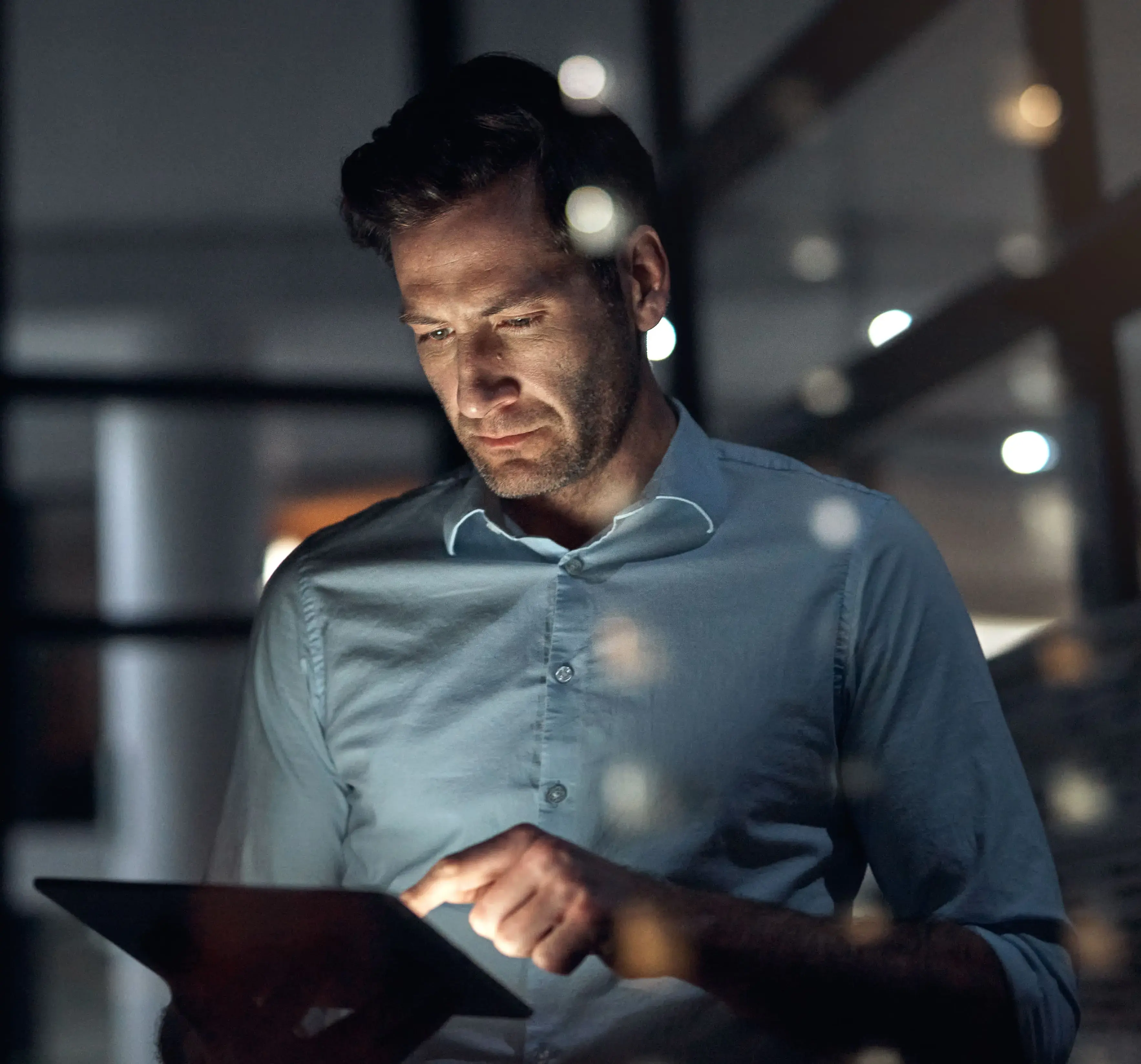 A man working on a tablet at night